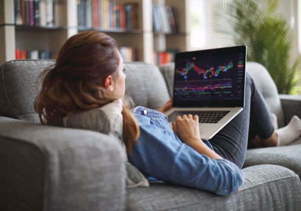 Frau sofa kurs boerse notebook gettyimages 1335958439